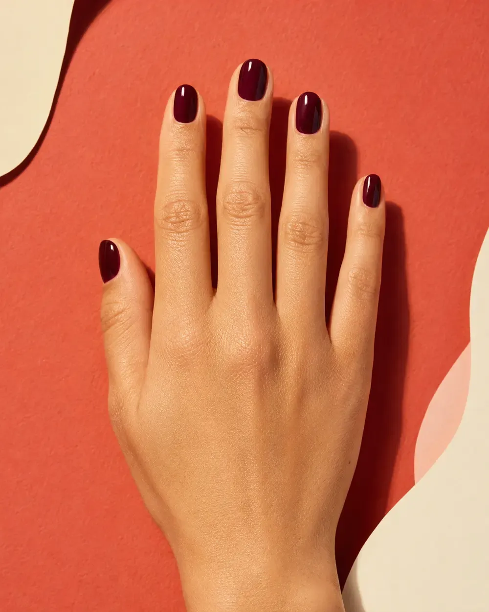 Editorial nail campaign in coral and oxblood tones