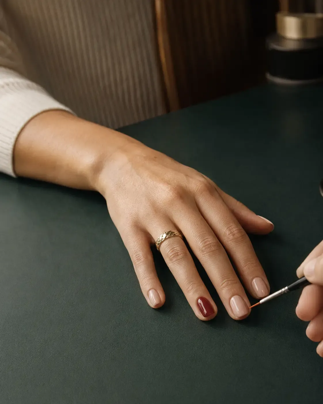 A nail professional completing a client’s manicure