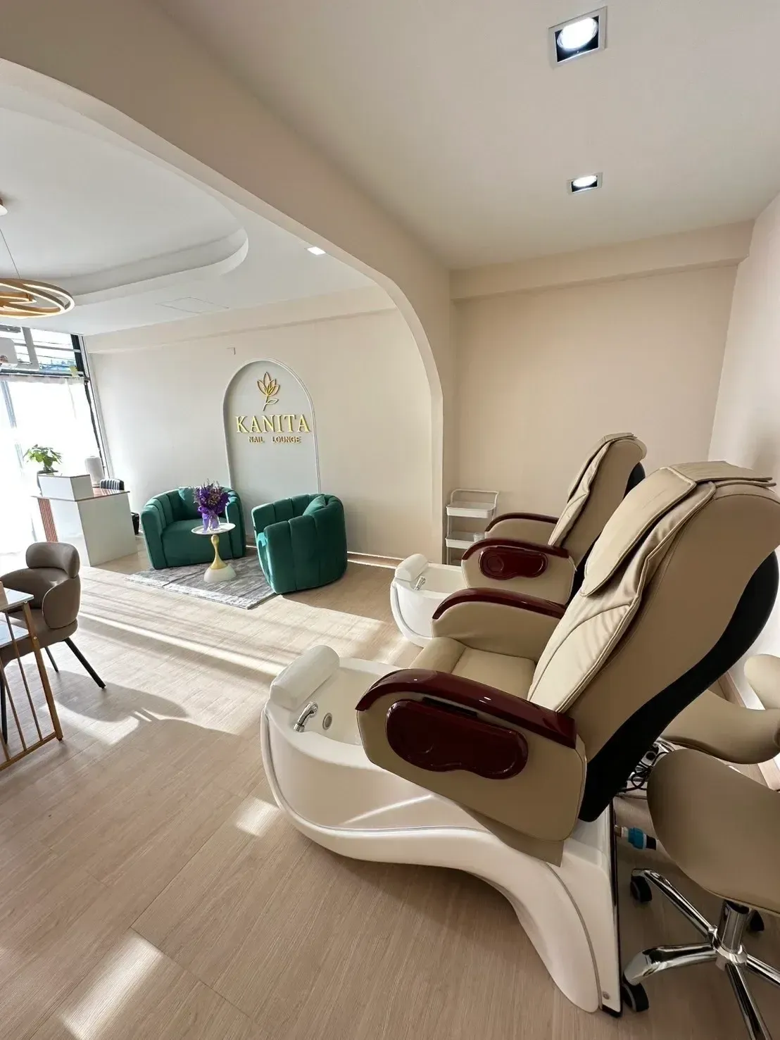 The real Kanita Nail Lounge interior with its salon sign, seating area and pedicure chairs